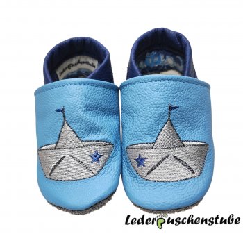 Lederpuschen hellblau-jeansblau, mit beiderseits Stickerei Papierboot (grau-anthrazit Stern und Fahne jeansblau)